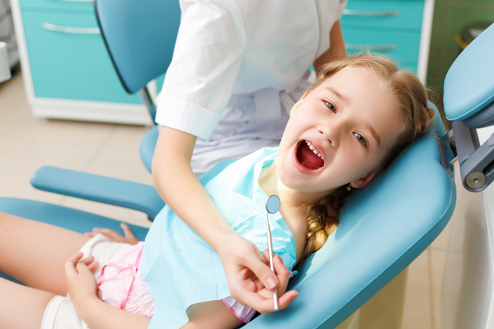 Little girl sitting in the dentists office